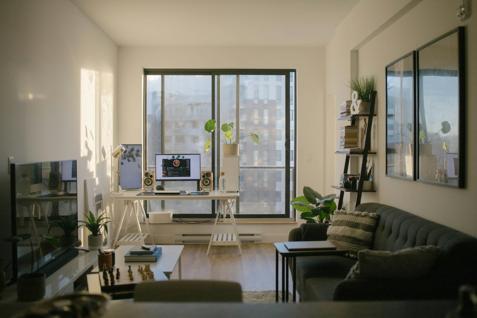 Salón luminoso con grandes ventanas y zona de trabajo